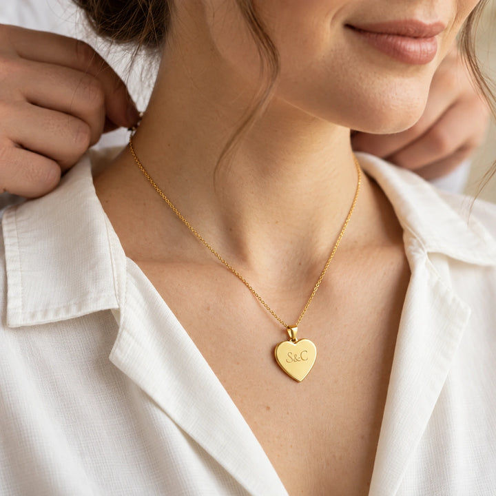 Personalized Heart Necklace "Love" as a gift for couples: gold heart pendant engraved with initials, worn on a white blouse – famwalls
