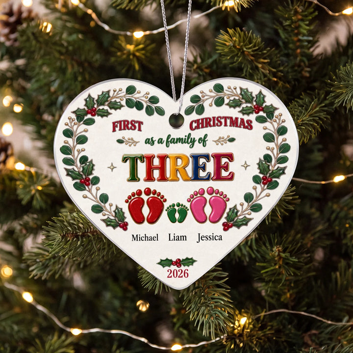 Personalized heart ornament "First Christmas Family Footprints" with colorful footprints and names of a family of three on the Christmas tree