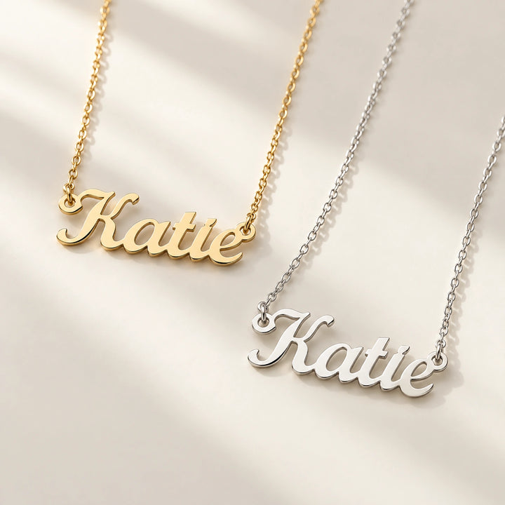 Gold and silver Name necklaces side by side on a beige background