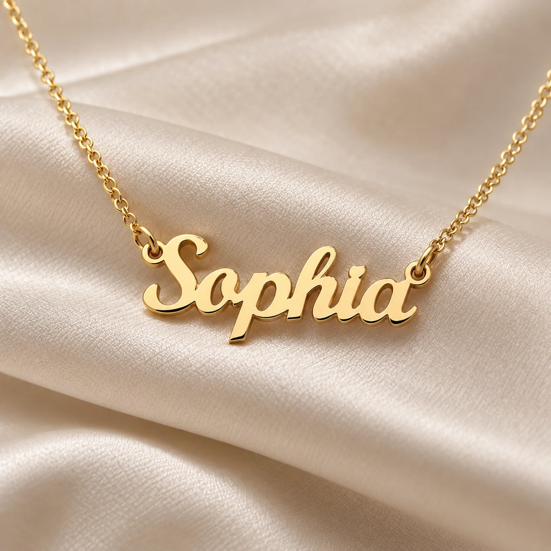 Gold Name necklace in script lettering on cream silk fabric