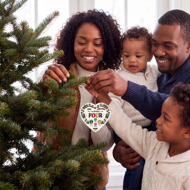 Family decorating the Christmas tree with their First Christmas as a family of four ornament