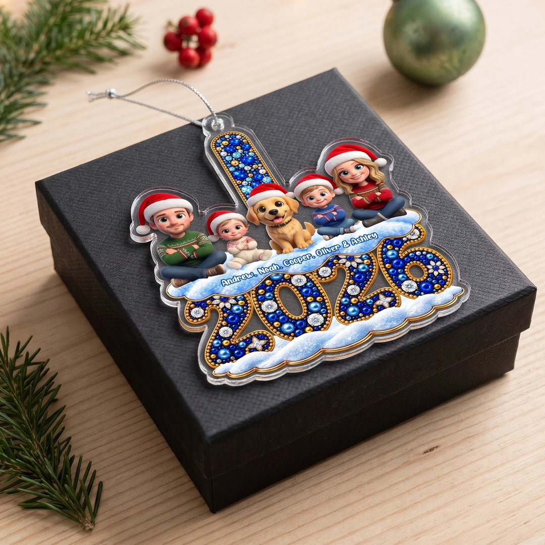 Family ornament with 3D cartoon figures, a dog and names above the sparkling 2026 on a black gift box