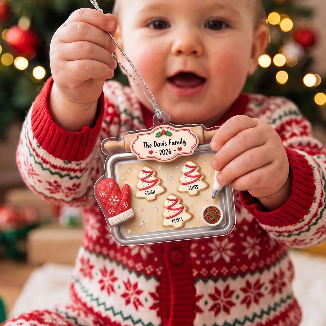 Baby in a Christmas sweater holds the Family Cookie Tray ornament with names
