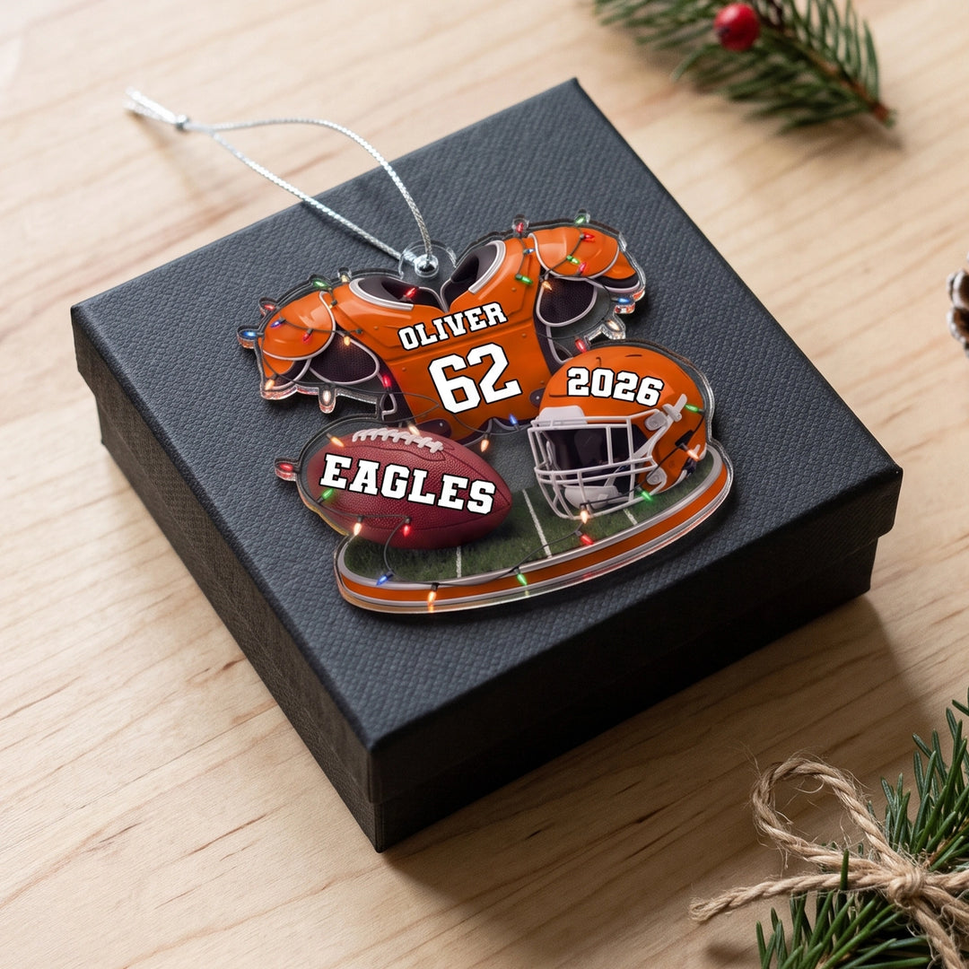 Orange Football ornament with name and number on a black gift box
