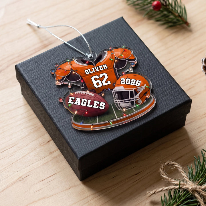 Orange Football ornament with name and number on a black gift box