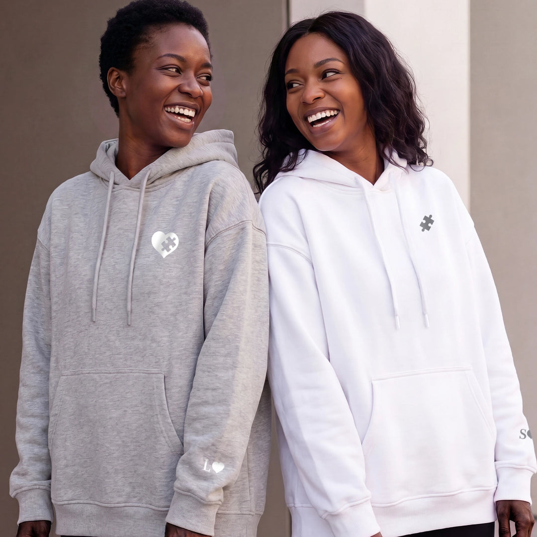 Two best friends wearing grey and white Besties Puzzle hoodies with heart and puzzle piece