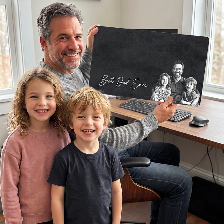 Dad and two kids holding the black Best Dad Ever desk mat with family sketch