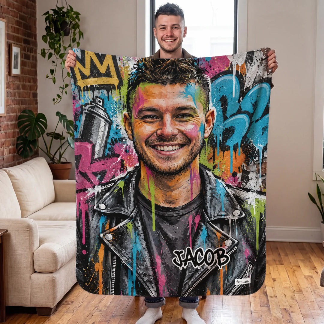 Man holds up his personalized graffiti blanket with the name Jacob