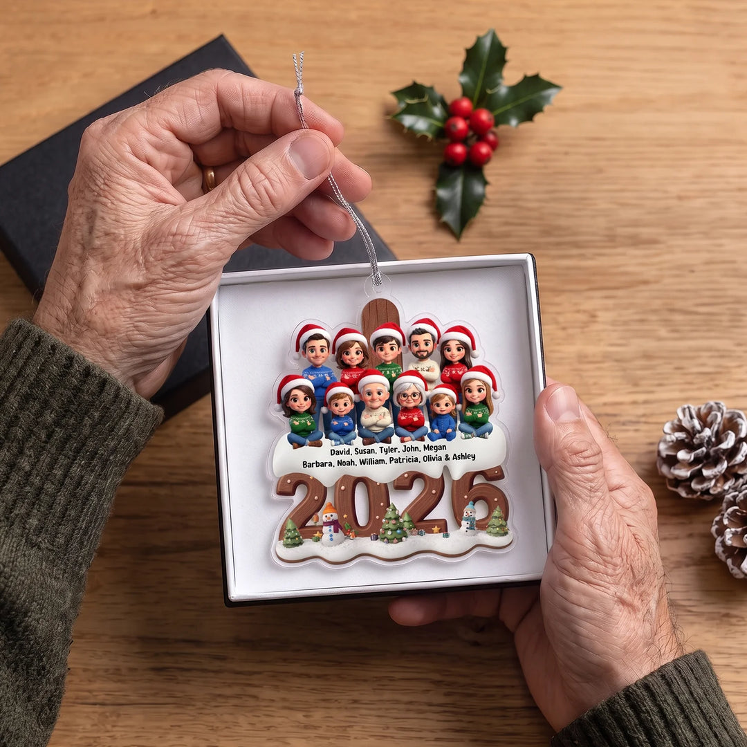 Hands holding the family ornament with twelve cartoon figures and their names in a white gift box