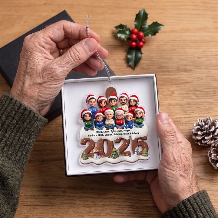 Hands holding the family ornament with twelve cartoon figures and their names in a white gift box