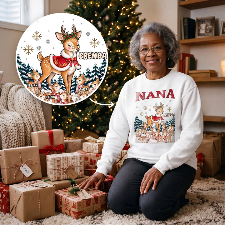 Grandma kneeling by the Christmas tree in a white personalized NANA sweatshirt with reindeer family and names