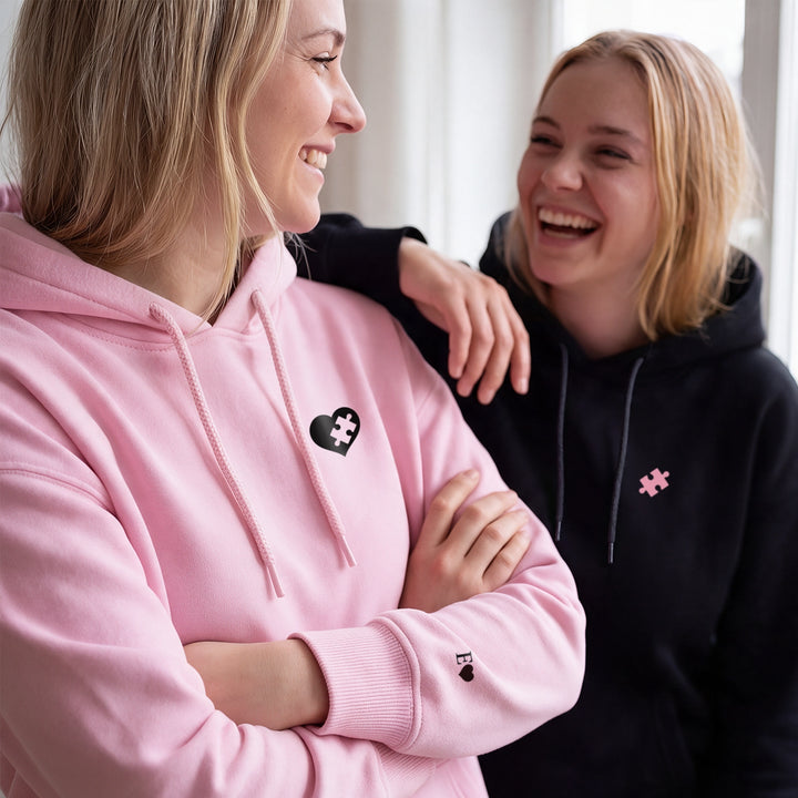 Best friends laughing in pink and black matching puzzle hoodies