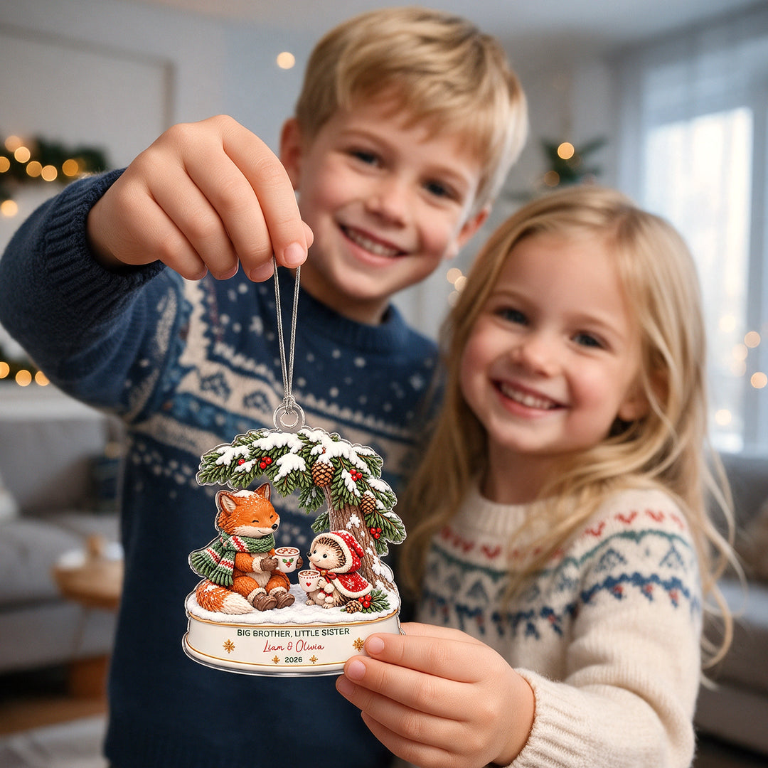 Brother and little sister hold up their Fox and Hedgehog ornament with their names