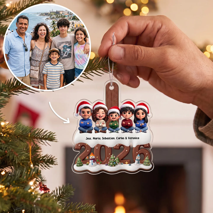 Family photo turned into five cartoon figures with Santa hats and names on the ornament, held in front of a Christmas tree