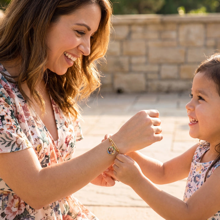 Mother and daughter laugh while holding hands with the Photo Circle bracelet