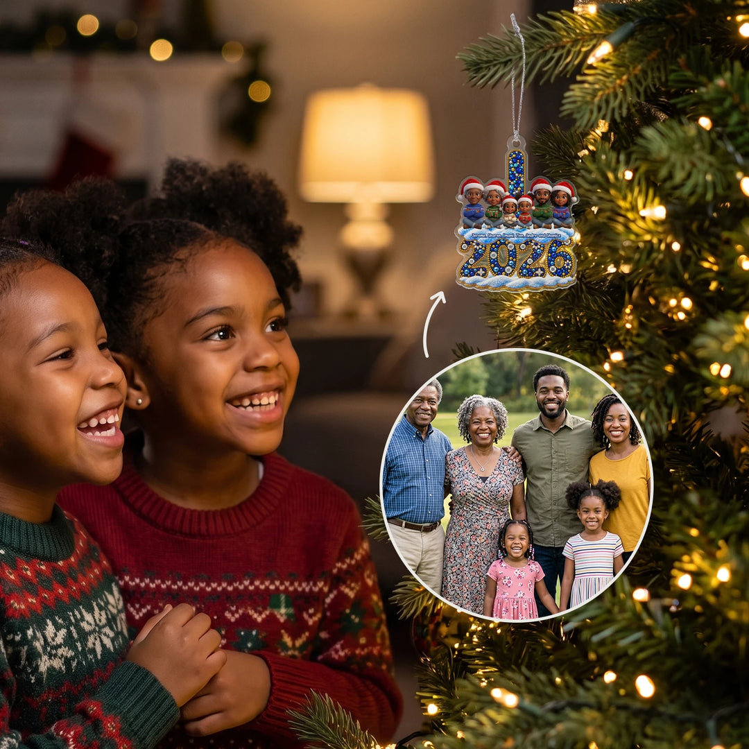 Two smiling girls looking at the personalized 2026 family ornament on the lit Christmas tree