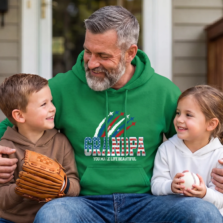Grandpa in a green GRANDPA American Legend hoodie with two grandkids and a baseball glove