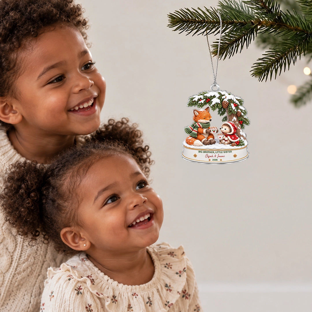 Two smiling sisters look at the Fox and Hedgehog ornament on the Christmas tree