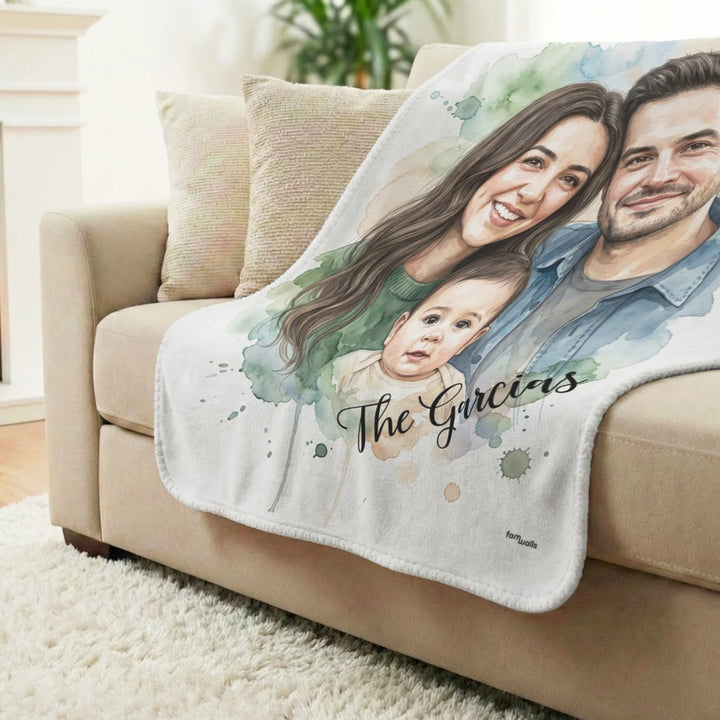 Family watercolor blanket with "The Garcias" draped over a beige sofa