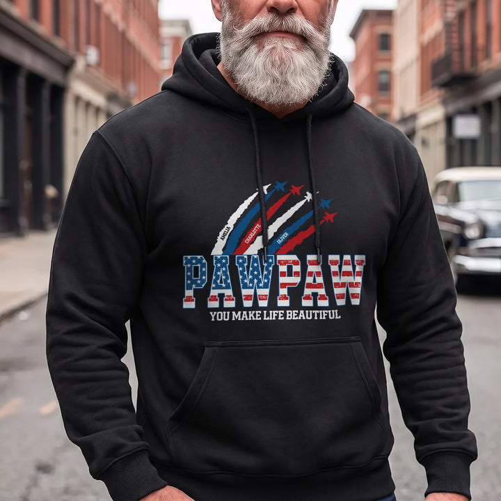 Bearded man in a black PAWPAW American Legend hoodie on a city street