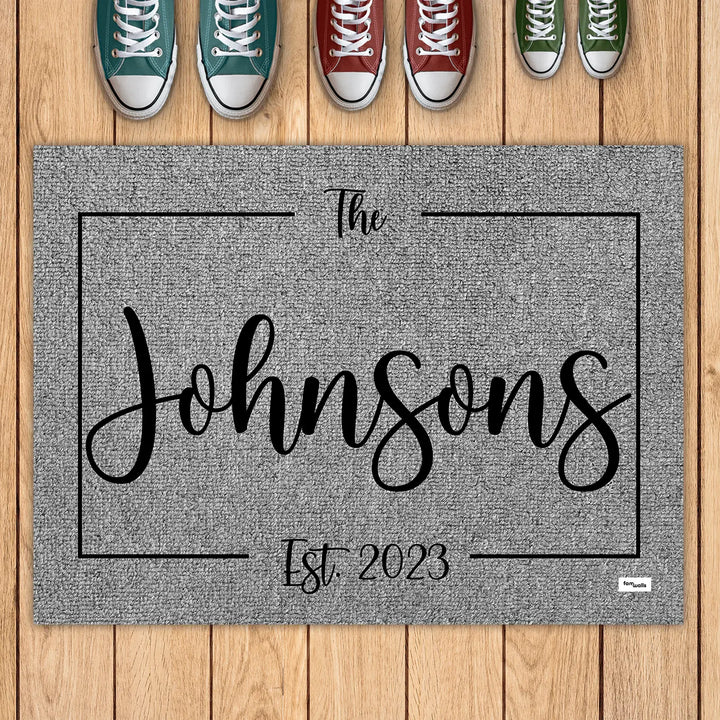 Gray family name doormat with sneakers lined up above it