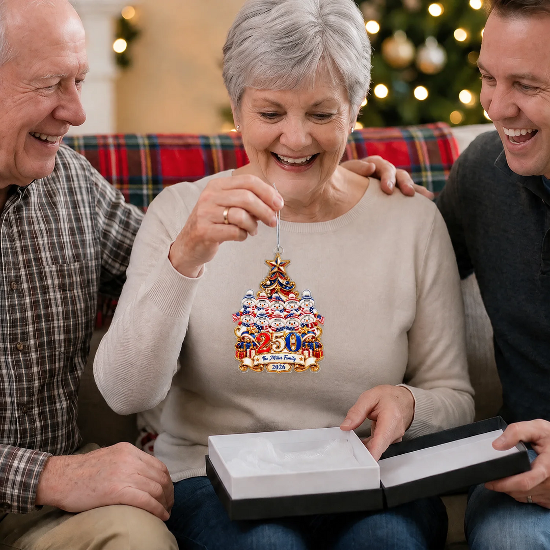 Grandma holding the Snowman 250 Years ornament of a big family next to an open gift box
