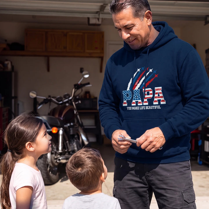 Dad in a navy PAPA American Legend hoodie talks to two kids in a garage